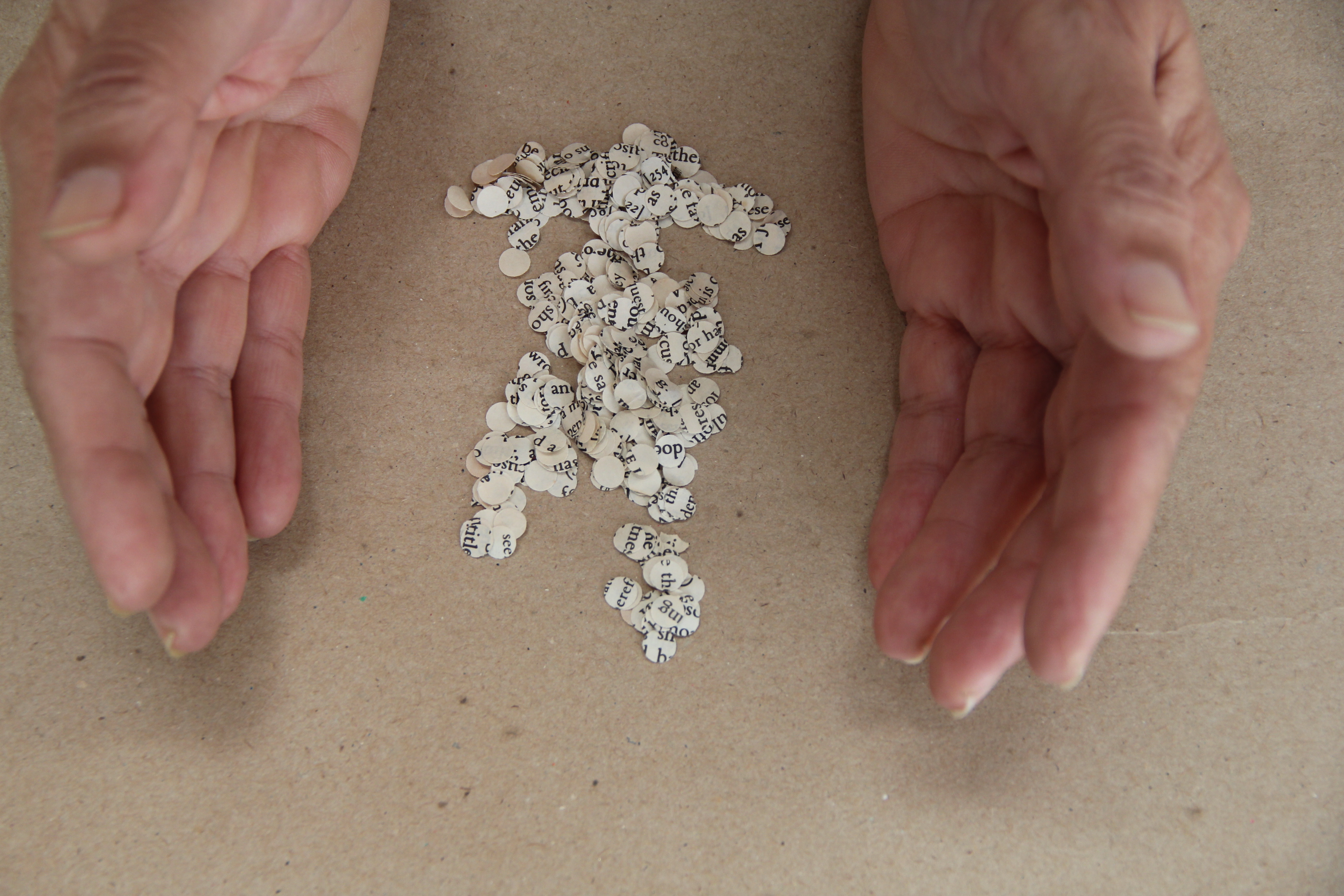 open hands scooping up circular clippings from newspapers